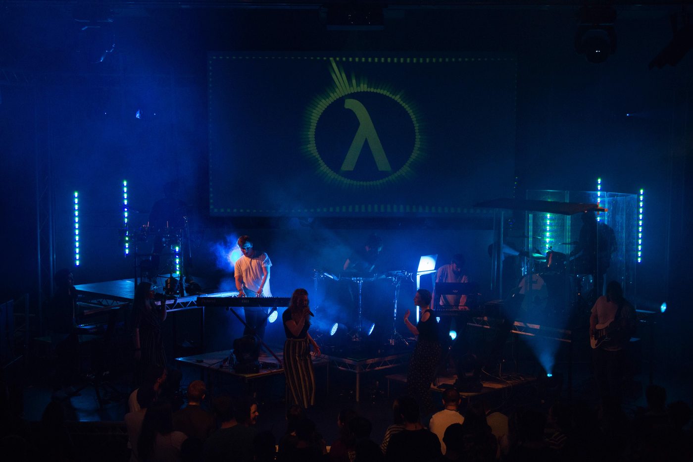 Live EDM production with LED bars, projection and haze