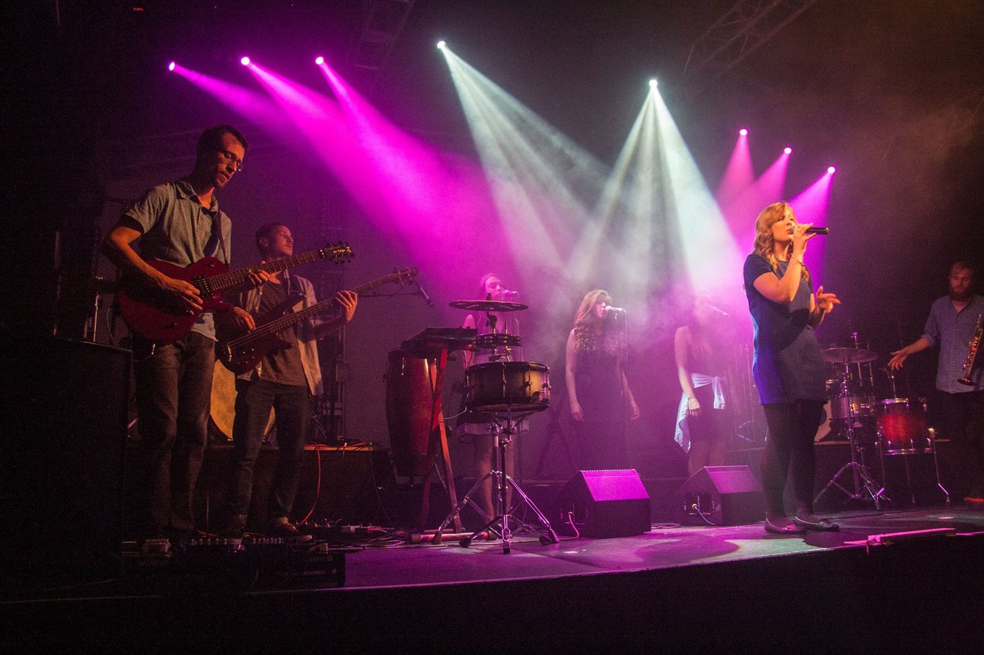 Live concert with dramatic pink and white stage lighting design